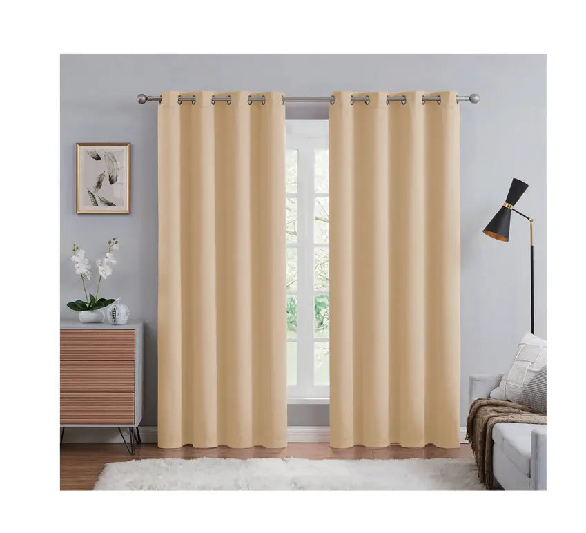 Beige curtains hanging in a room with a window, lamp, and decor items.