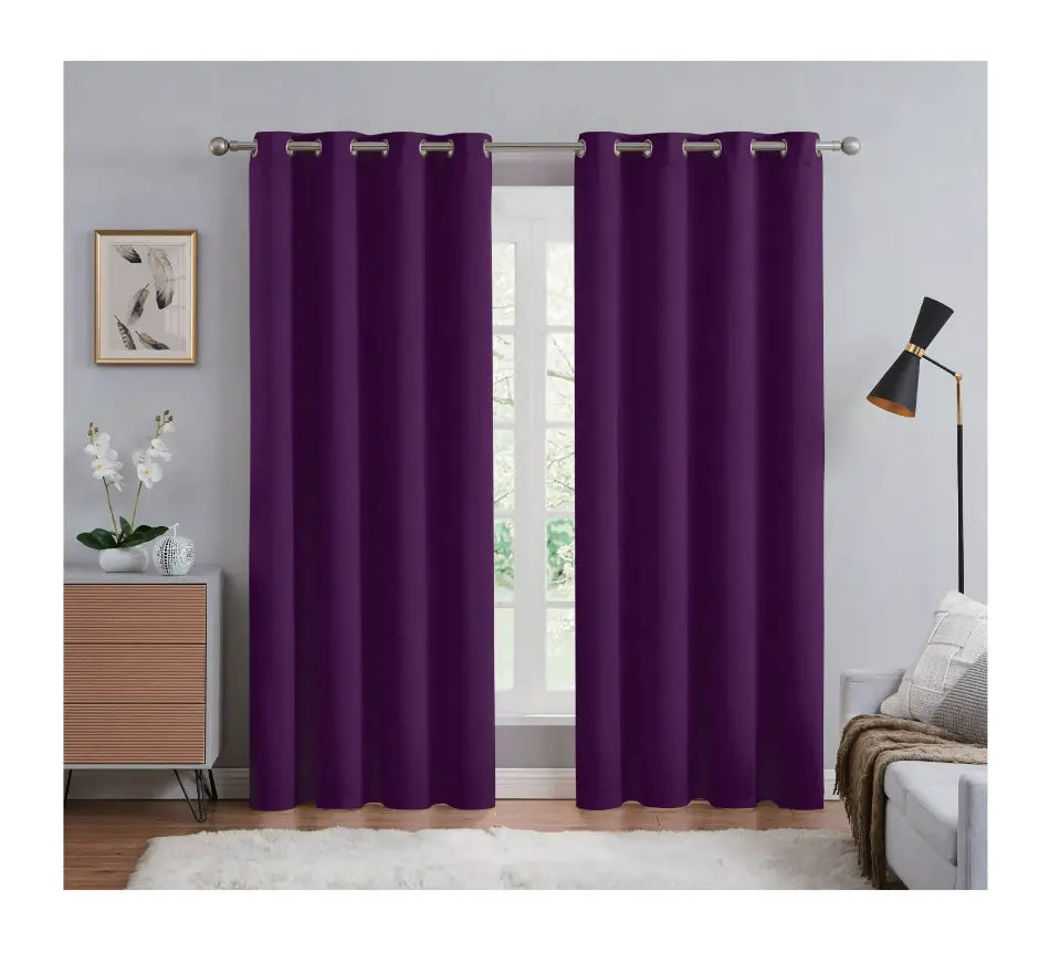 Purple curtains hanging in a room with a window, furniture, and decor.