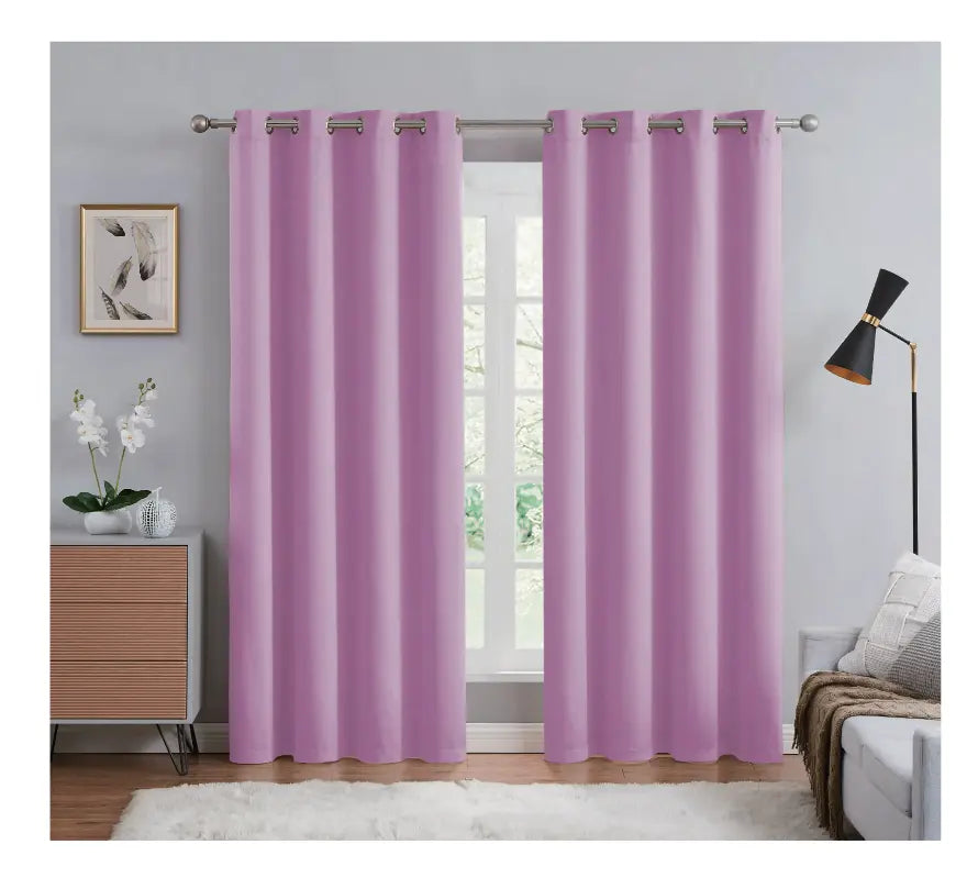 Purple curtains hanging in a room with a window, dresser, and lamp.