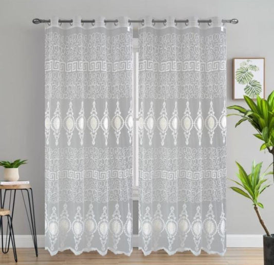 Sheer curtains with geometric pattern on a gray wall background