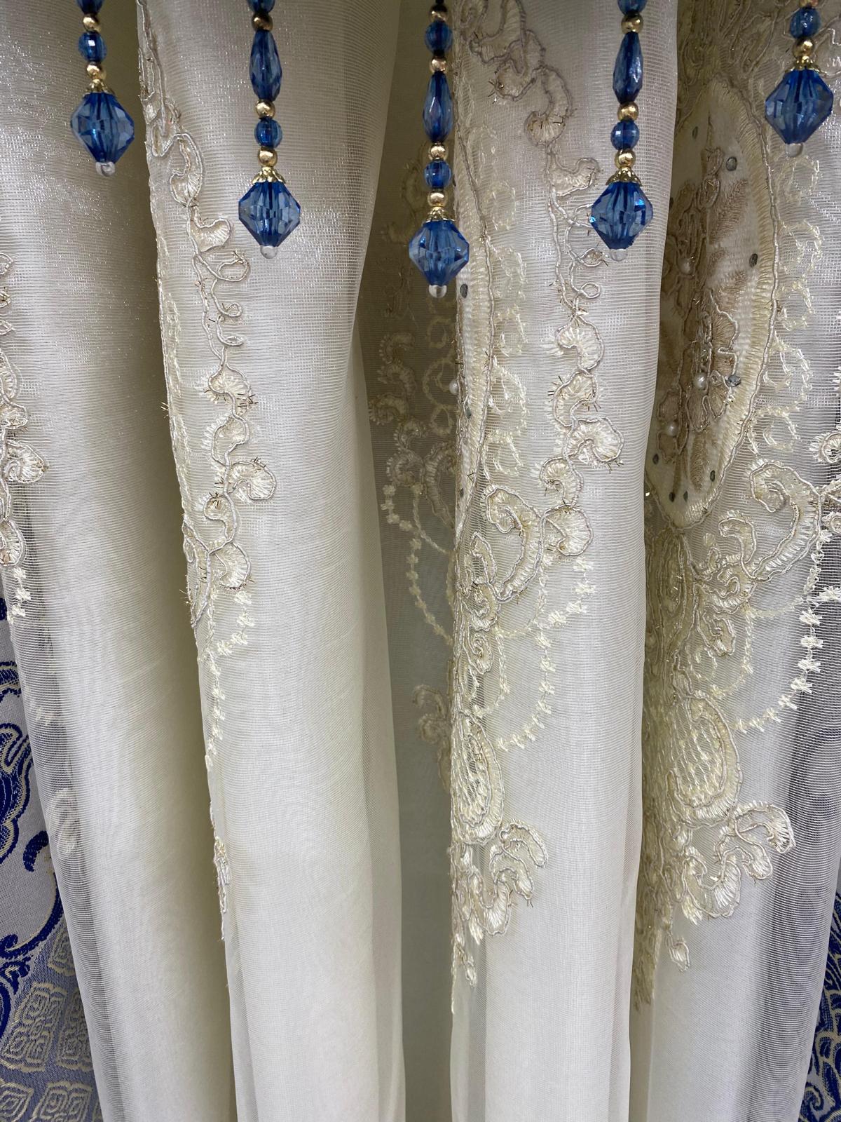 White lace curtain with blue beaded trim