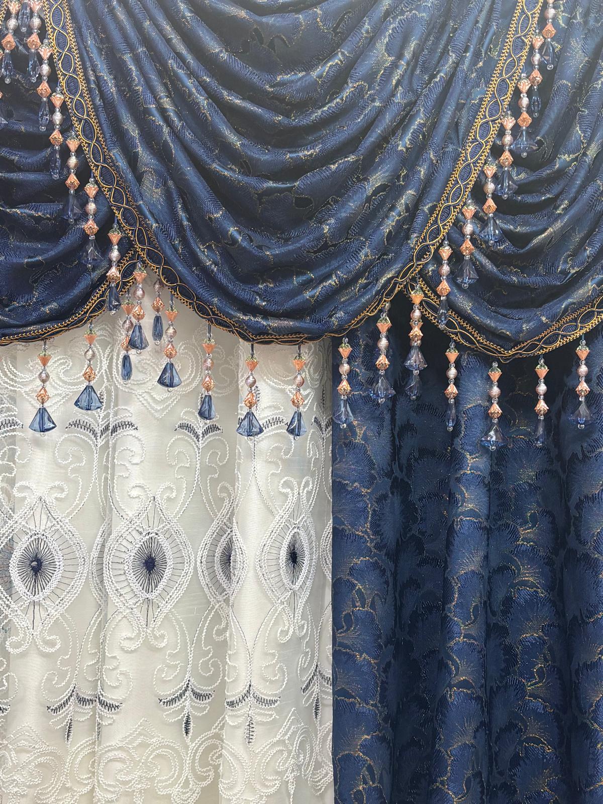 Decorative blue and white curtains with intricate patterns and beaded trim.