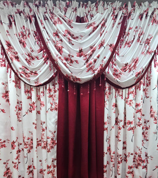 A set of curtains featuring a white base with a red cherry blossom floral print, styled with a central deep red valance and matching red hanging panels.